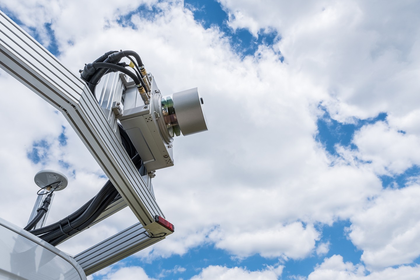 Eingehauster  3D-Laserscanner –  fertig montiert auf dem Dach eines Messfahrzeugs. 