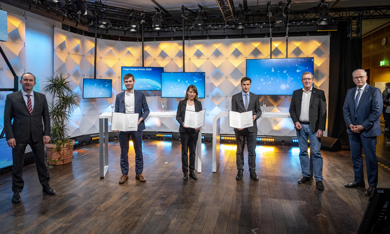 Minister Hubert Aiwanger mit den Hugo-Geiger-Preisträgern: Dr. Simon Fichtner, Dr. Annelie Schiller,  Dr. Christian Kalupka.  Zu den Gratulanten gehörten auch die Fraunhofer-Vorstandsmitglieder Andreas Meuer und Prof. Alexander Kurz (v.l.n.r.).